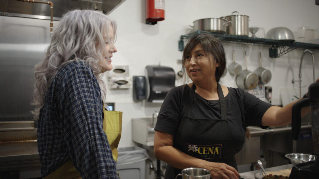 Maggie chats with a chef in the kitchen